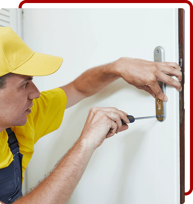 A man in yellow shirt and hat working on door.