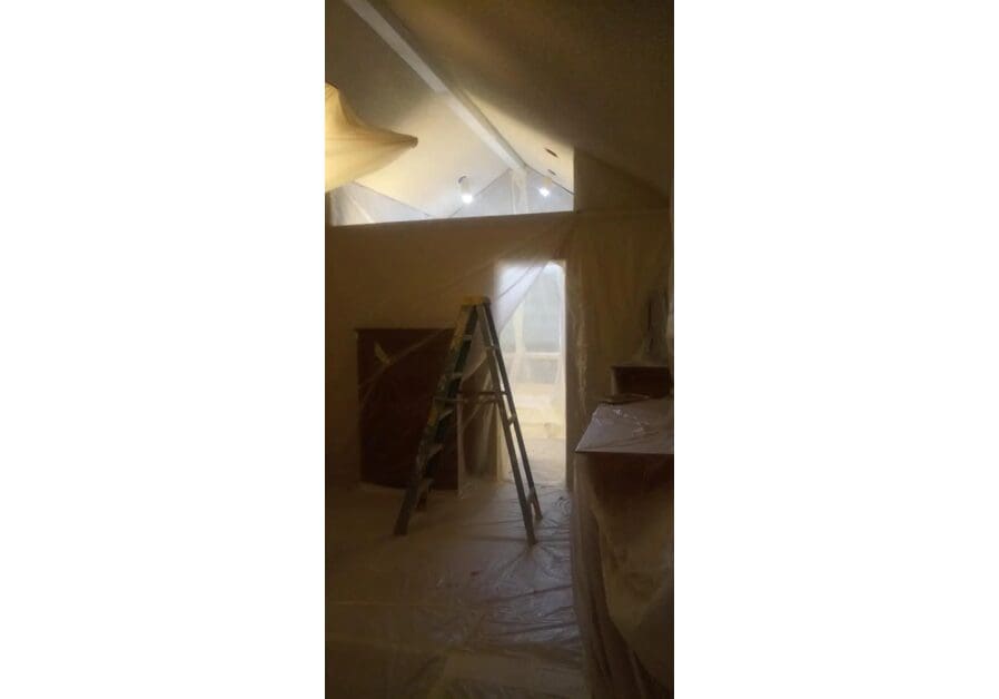 A ladder in the middle of an attic.
