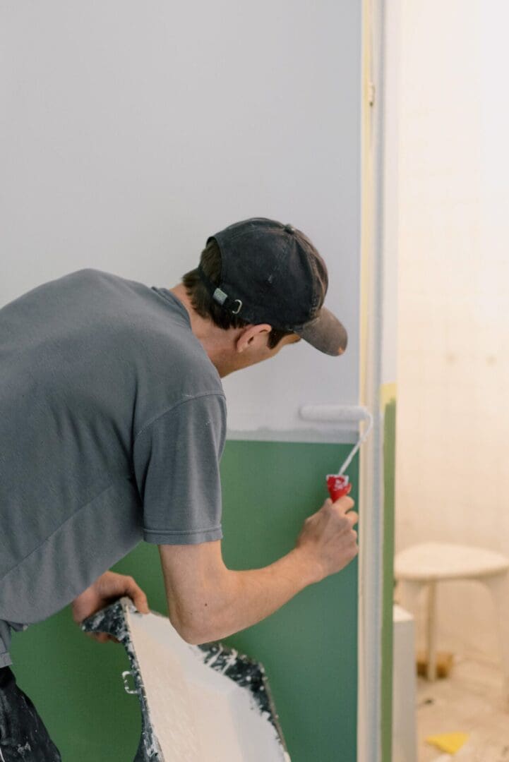 man finishing interior trim painting