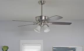 Ceiling fan installation with lights mounted on a white ceiling.