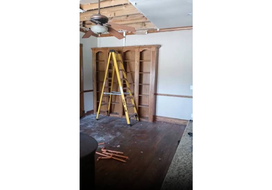 A ladder in the middle of a room with some wooden floors