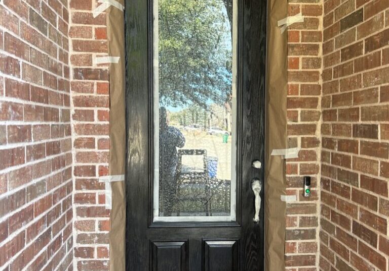 A front door with protective tape and covering during a home renovation or door staining.